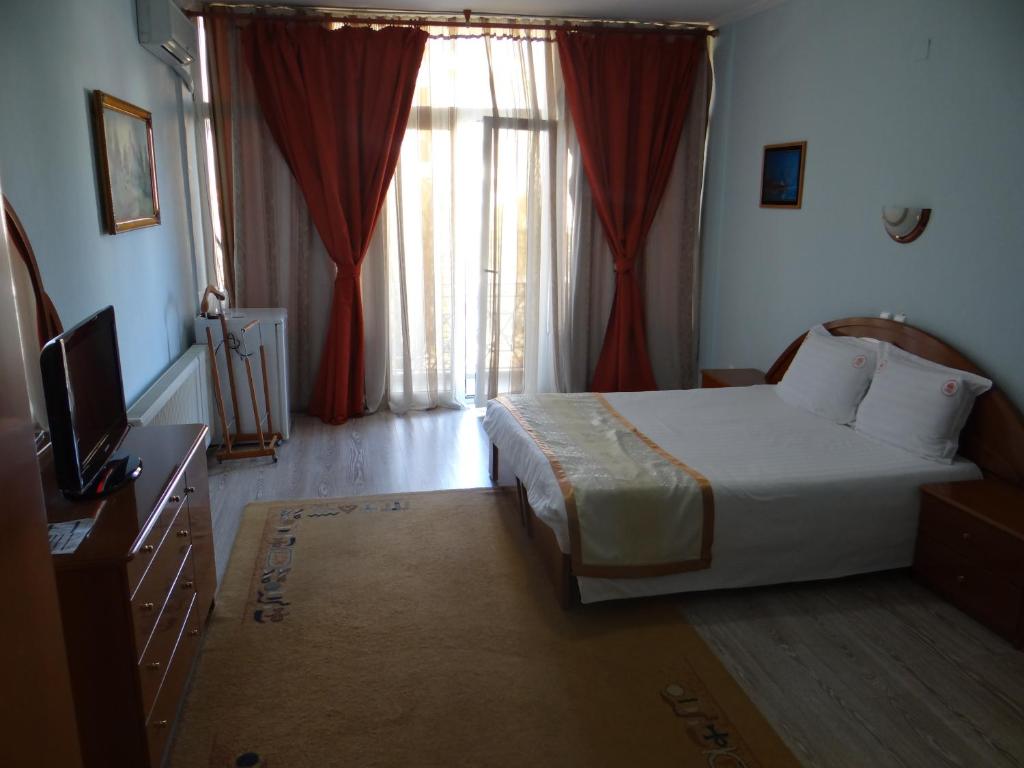 a bedroom with a bed and a television and a window at Hotel Konti in Korçë