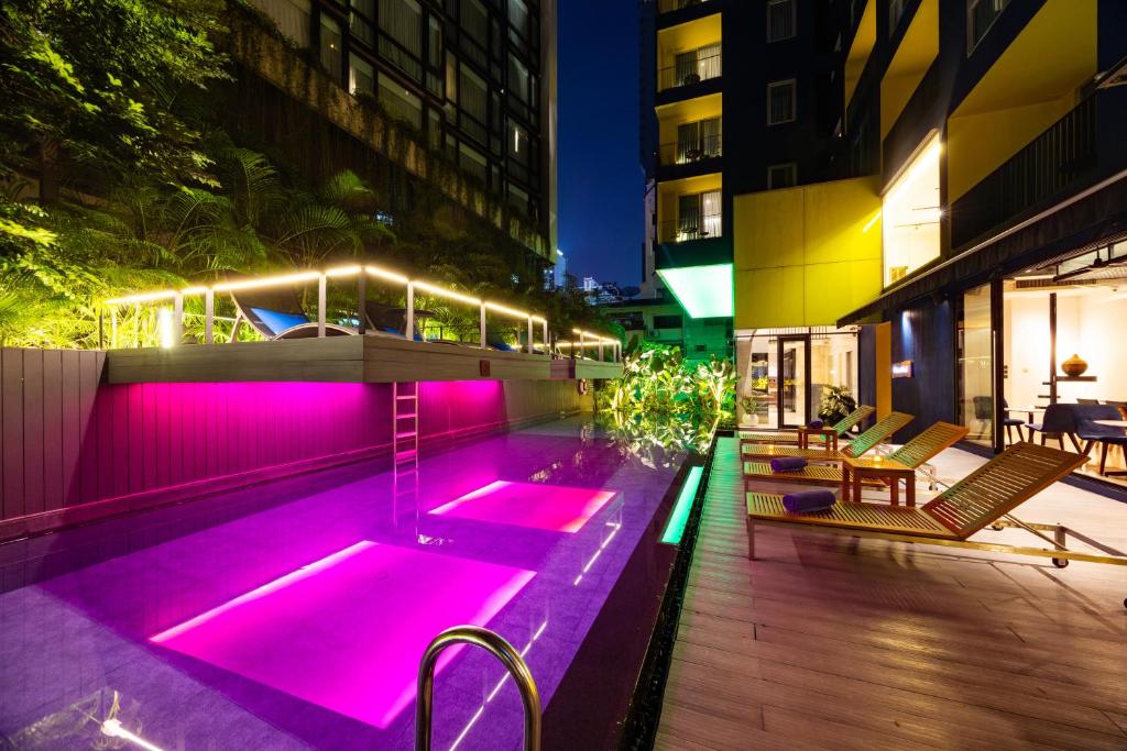 A narrow illuminated pool courtyard between the hotel buildings.