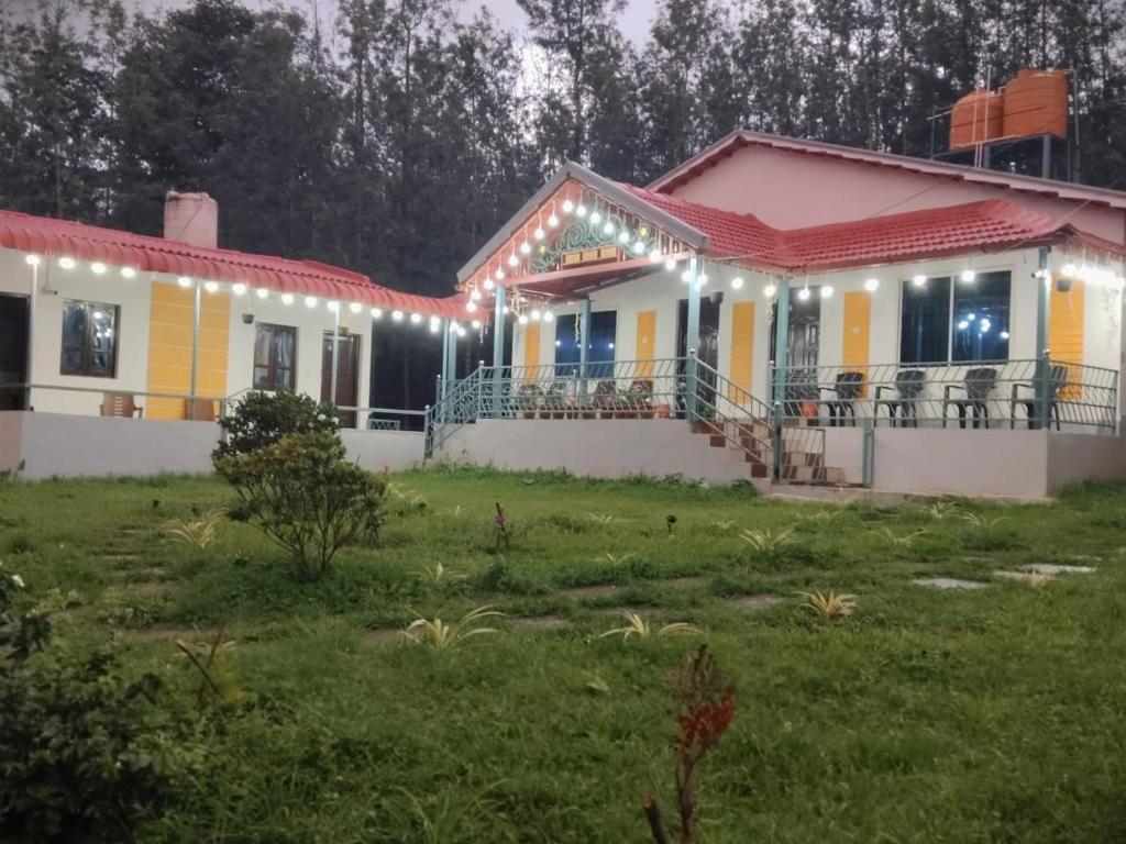 a house with lights on it in a yard at Malnad Mist in Attigundi