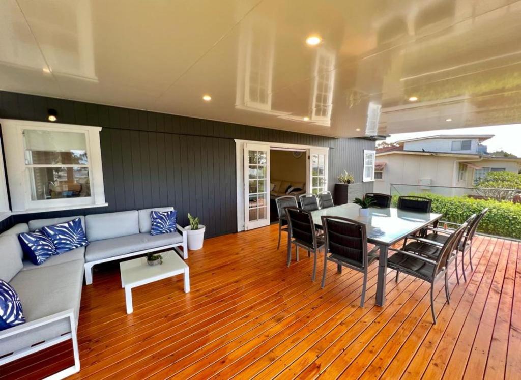 a living room with a couch and a table and chairs at Barefoot and Beach Bound by Book Jervis Bay in Vincentia