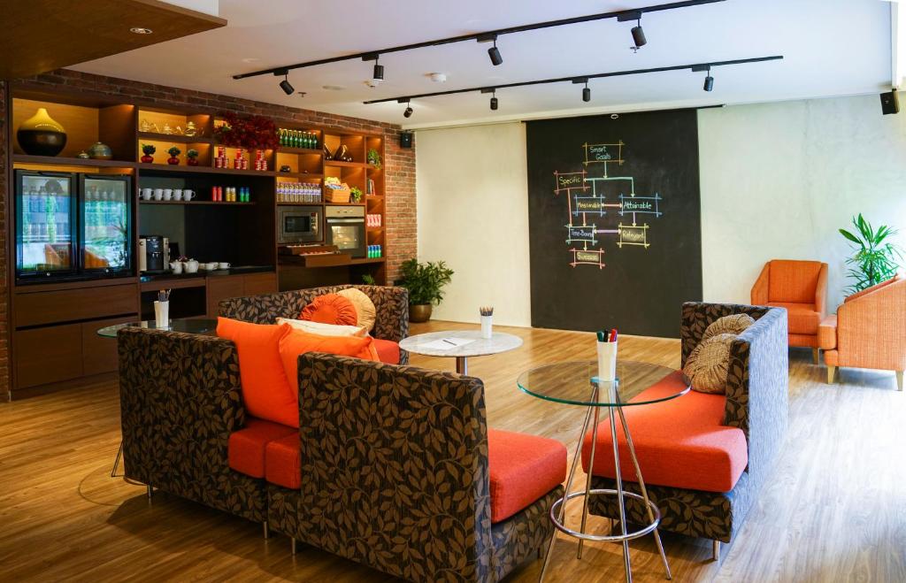 A bright lounge area offers upholstered seating, tables and a large chalkboard wall.