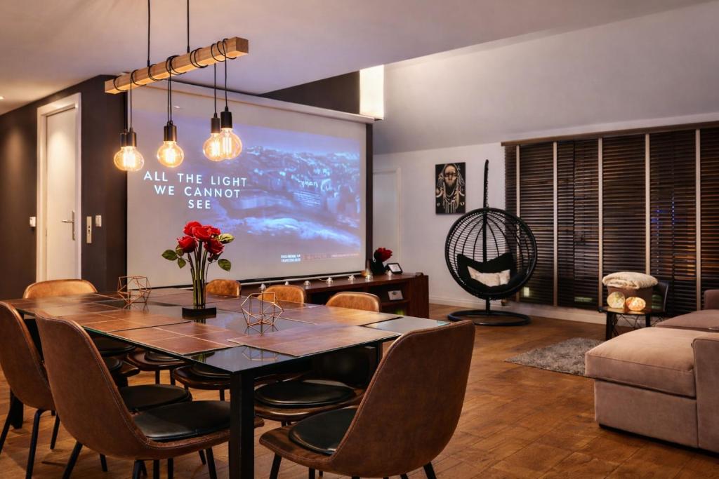 a living room with a table and a large screen at Luxury Loft Duplex Penthouse Of 190m2 & Free Parking ! in Brussels