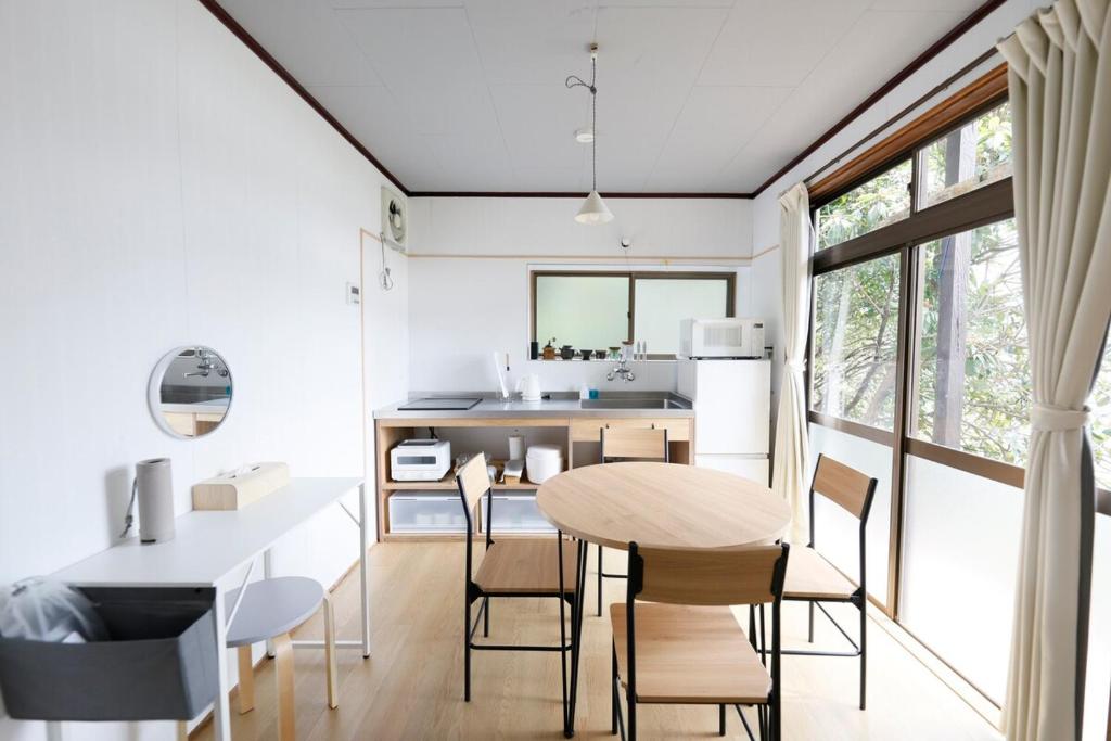 a kitchen and dining room with a table and chairs at CLIP INN by RITO 坂の上の一棟貸し in Tsushima
