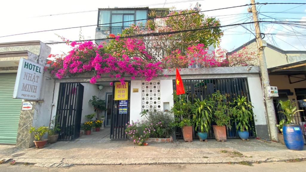 a building with flowers and plants in front of it at Nhật Minh Hotel in Thuan An
