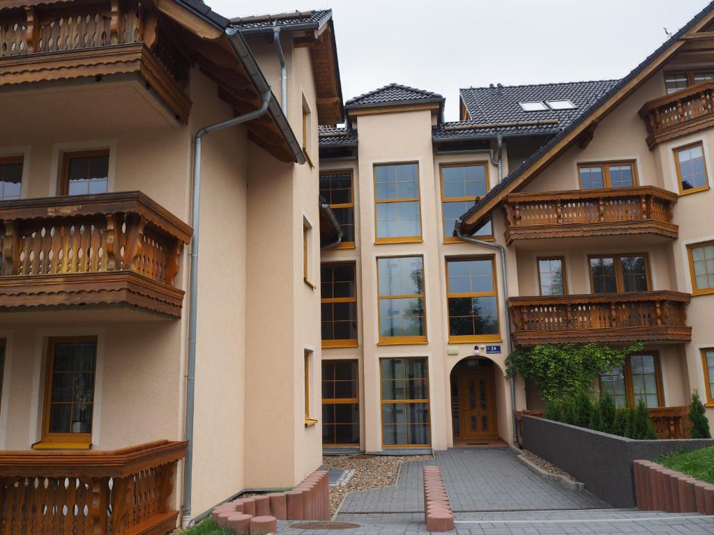 eine Reihe von Häusern mit Balkon und Auffahrt in der Unterkunft Apartament DOMINO in Karpacz