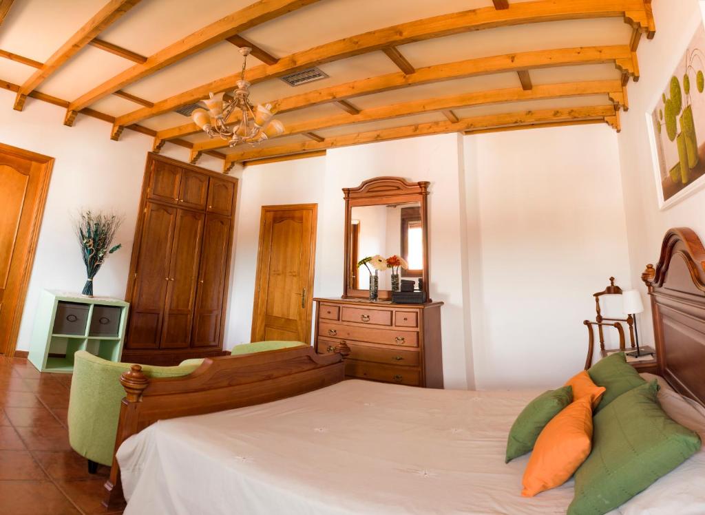 a bedroom with a bed and a dresser and a mirror at Apartamentos Rurales El Prado in Pinofranqueado