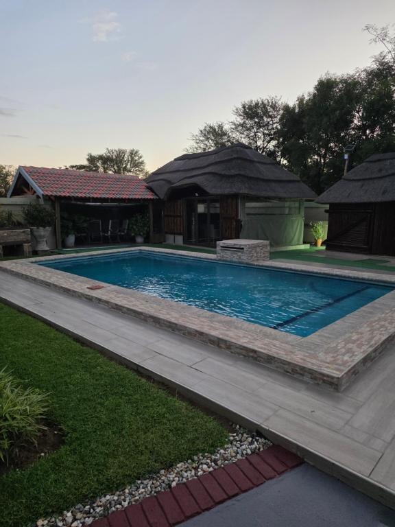 a swimming pool in a yard with a house at CLP Lodge in Bela-Bela