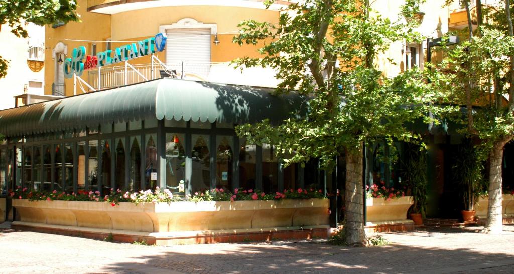 a building with a store with flowers in front of it at Hotel Dei Platani in Rimini