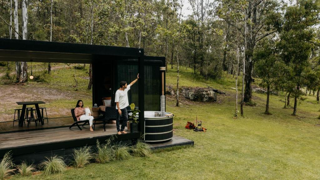 a man standing on the deck of a tiny house at The Lantern - a Huch experience in Wollombi