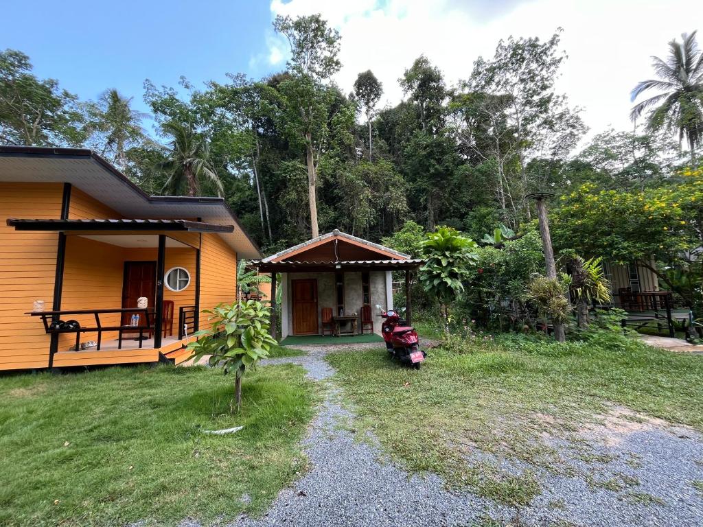 a house with a scooter parked in front of it at Lung peiyk homestay in Ban Bang Bao