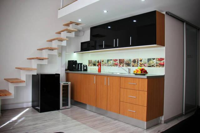 una cucina con lavandino, armadi in legno e scale di Walkway Apartment Deluxe a Budapest