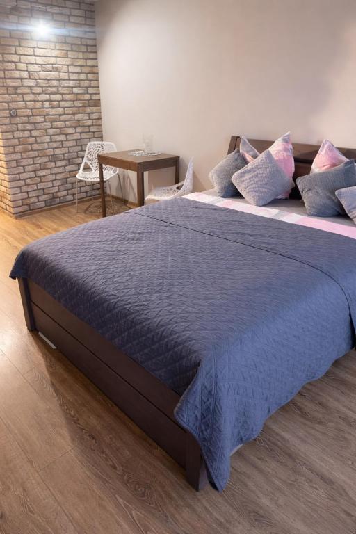 a large bed with blue sheets and pillows on it at studio Szymanowskiego 5 in Szczecin