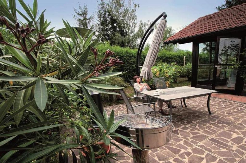 a person sitting at a picnic table in a garden at Haus "Am Mühlheimer Berg" in Mörnsheim