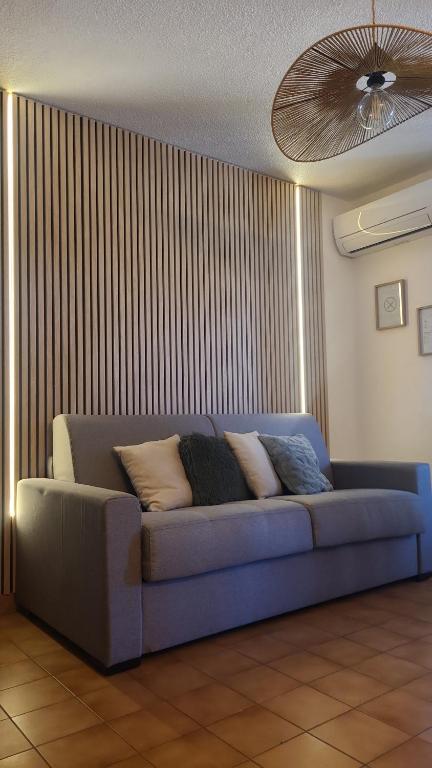 a blue couch in a living room with a ceiling at SERENATA - Studio climatisé sur le Port - Piscine & Tennis in Sausset-les-Pins