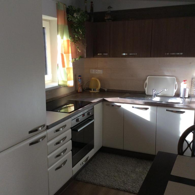 a kitchen with white cabinets and a stove top oven at Apartment Garden in České Budějovice