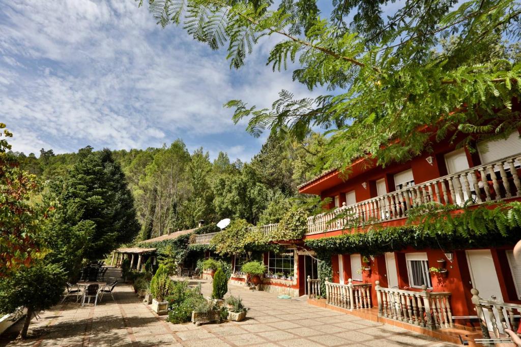 um edifício com plantas ao lado dele em Hotel Rural Noguera de la Sierpe em Arroyo Frio