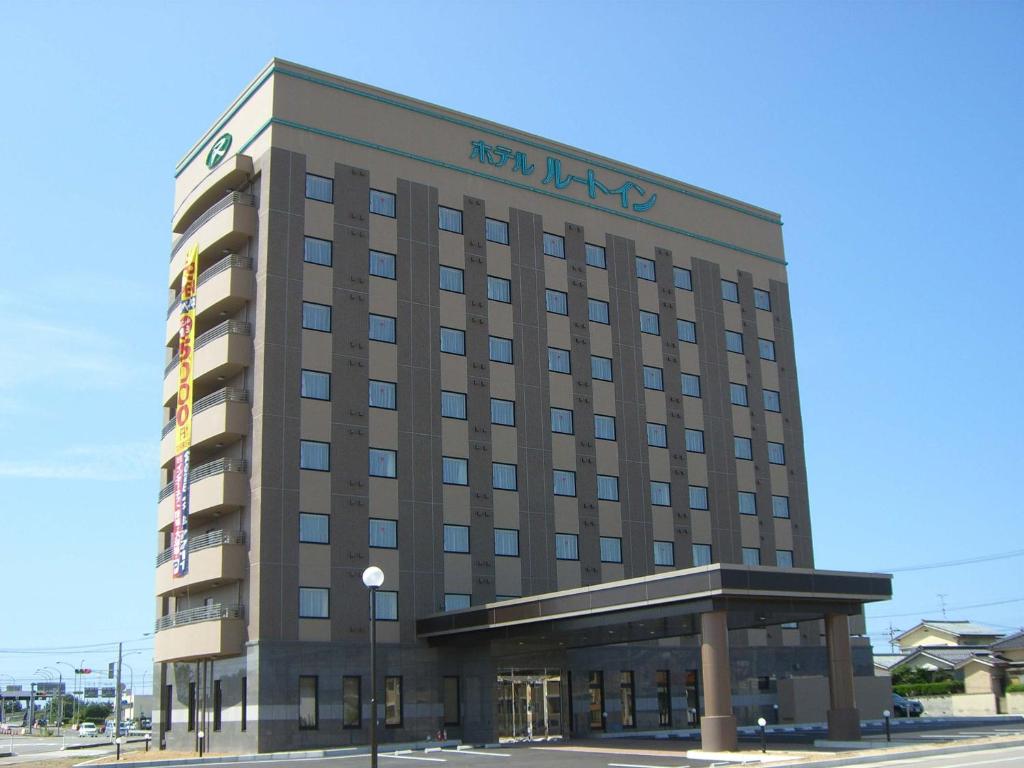a hotel building with a sign on top of it at Hotel Route-Inn Mikawa Inter in Hakusan