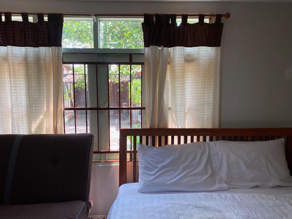 a bedroom with a bed and a window with a laptop at เรือนเงินตรา in Ban Khlong Hok