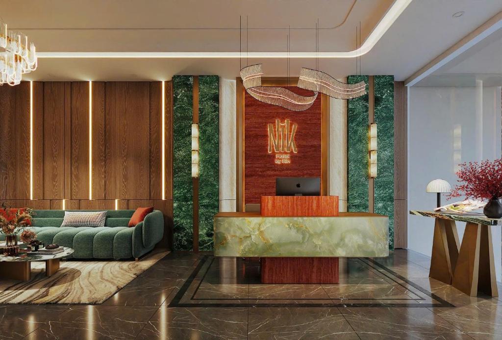 a living room with a green couch and a table at NiK Hotel Thi Sach in Ho Chi Minh City