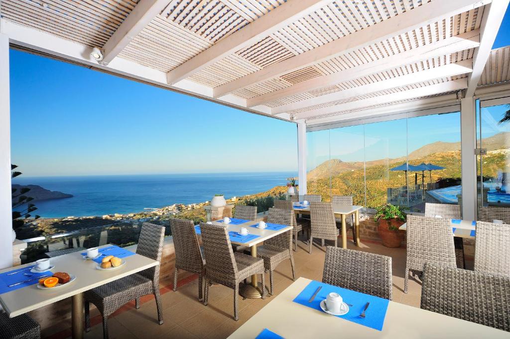 a dining room with a view of the ocean at Stefanos Village Hotel in Plakias