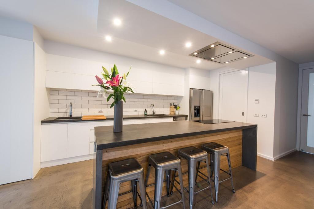 a kitchen with a island with a vase of flowers at The Bright House in Bendigo