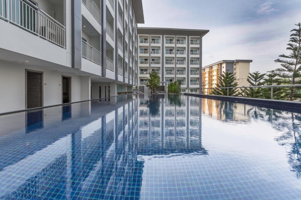 a swimming pool in front of a building at Kantary Hotel And Serviced Apartment, Amata, Bangpakong in Ban Tamru