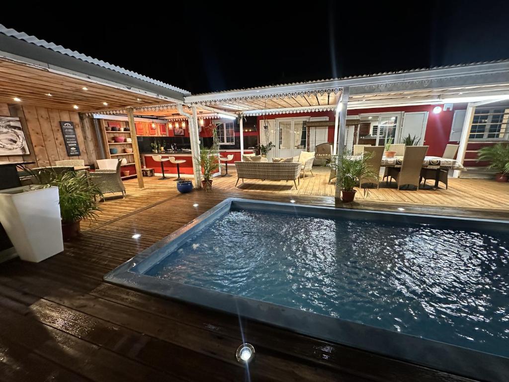 a swimming pool in the middle of a patio at night at Le coin des romarins in Saint-André