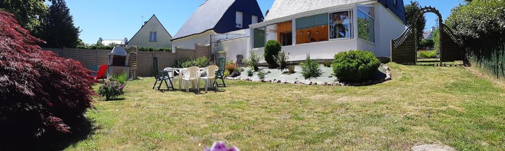 a house with a table and chairs in the yard at L'escale Kénanaise in Saint-Quay-Perros