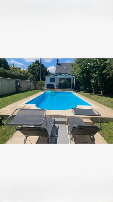a group of lounge chairs and a swimming pool at Petit chalet cosy house in Hermanville-sur-Mer