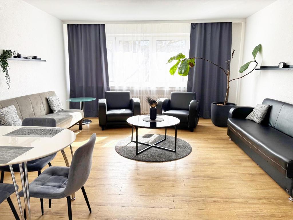 a living room with couches and a table and chairs at 3 Zimmer Apartment mit Garten in Wuppertal