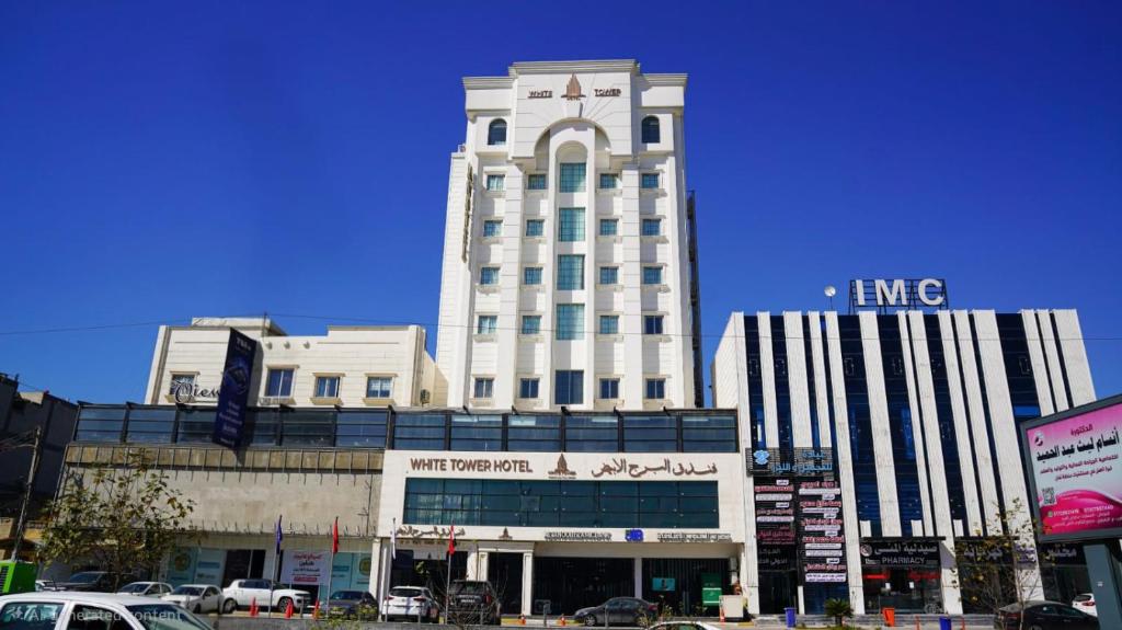 a tall white building with a sign on top of it at فندق البرج الابيض - White Tower Hotel in Ōlmush