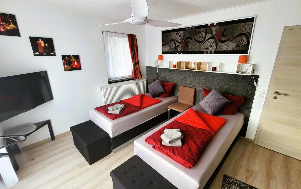 a living room with two beds and a couch at APARTMENTHAUS "AM KORNFELD" - 10 Gästewohnungen mit 1-3 Schlafzimmern, 40 Betten, Raucherbalkon, Reinigungs- & Wäscheservice, Grillgarten, Parkplatz in Lünen