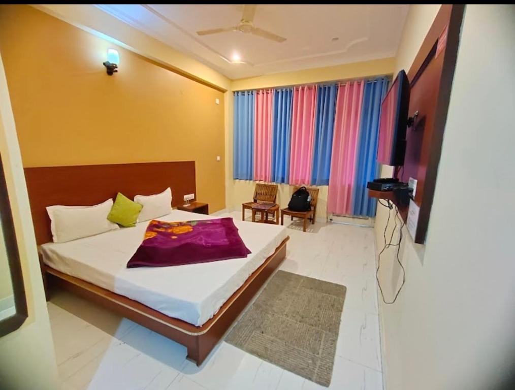 a bedroom with a bed and a television in it at Red carpet hotel in Kangra