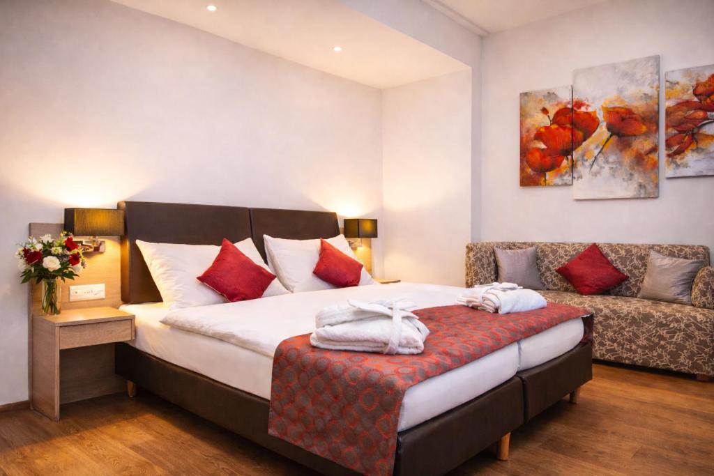 a hotel room with a bed and a couch at Hotel Alexander in Basel