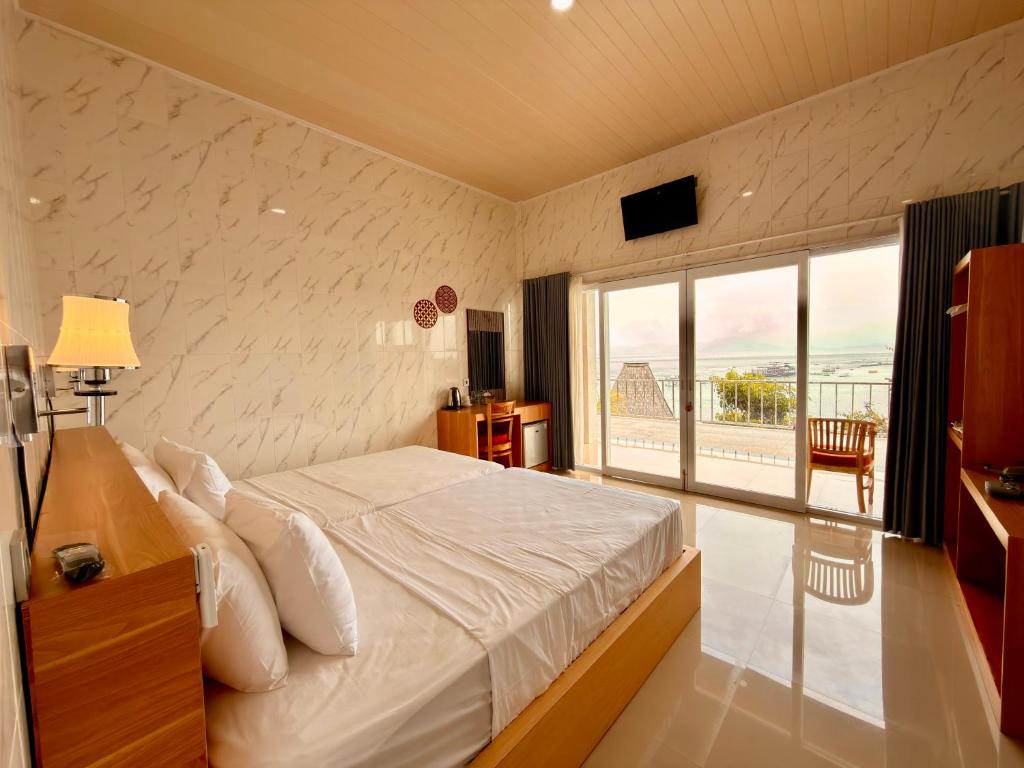 a bedroom with a bed and a large window at Prasi Sunrise Sea View in Nusa Penida