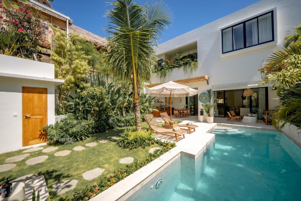 a backyard with a swimming pool and a house at Casa Capucine Uluwatu in Uluwatu