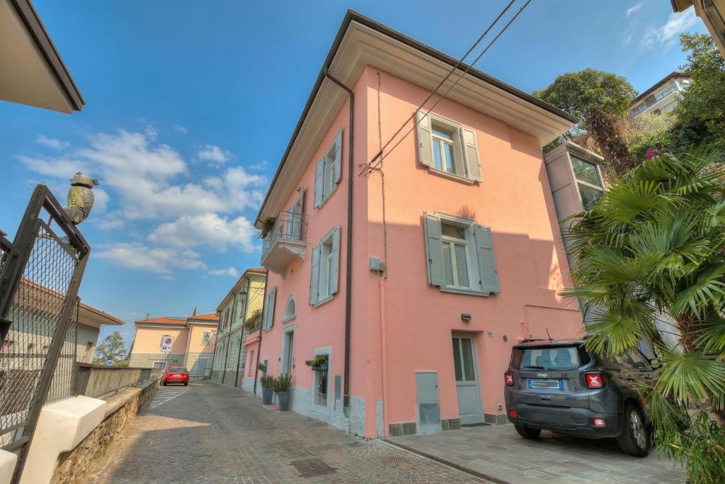 a car parked in front of a pink building at Vida Boa Apartments in Nago-Torbole