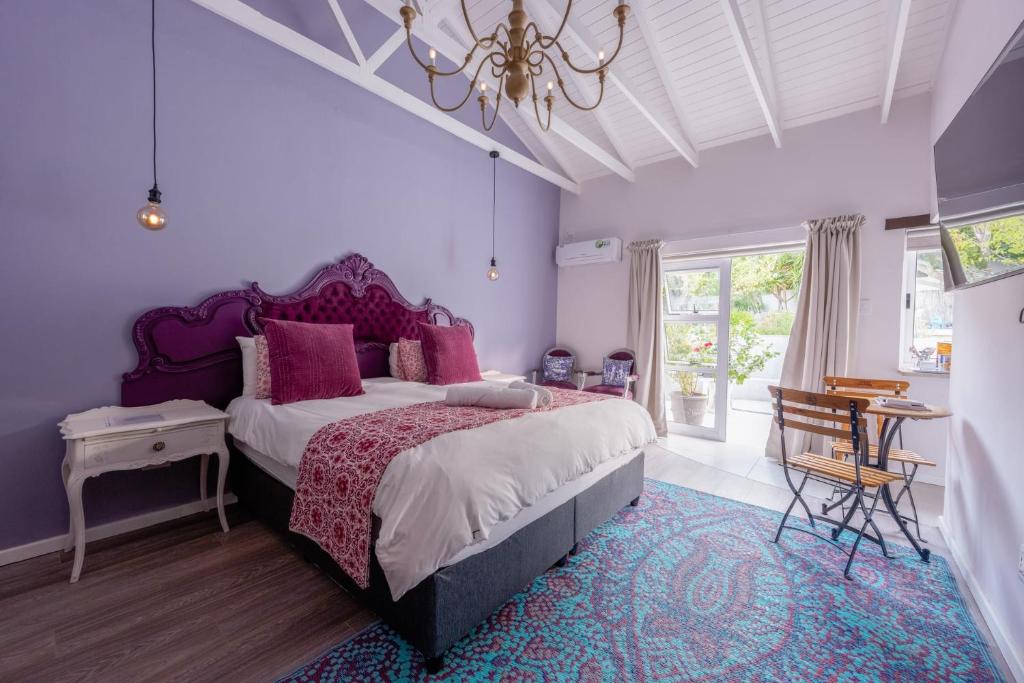 a bedroom with a large bed and a chandelier at The Botanical House in Somerset West