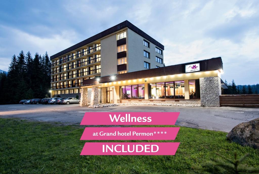 a building with a sign that reads wellness at grand hotel premier at Hotel Pieris in Podbanske