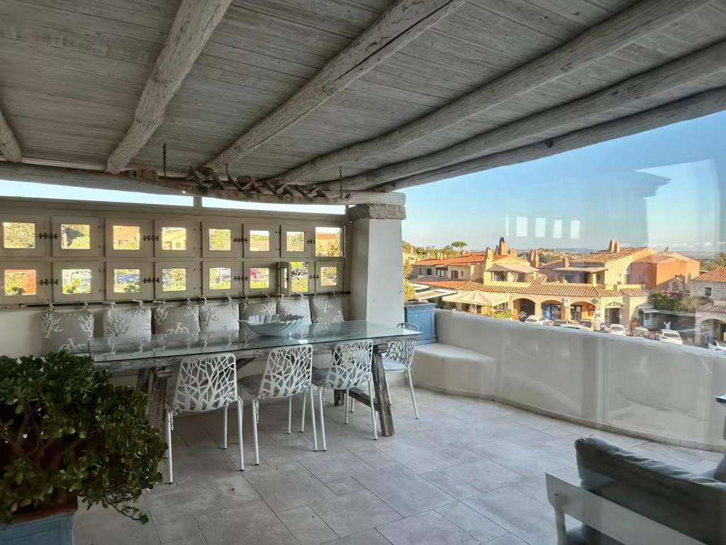 a patio with a table and chairs on a balcony at Hotiday Apartment Liscia Di Vacca in Porto Cervo