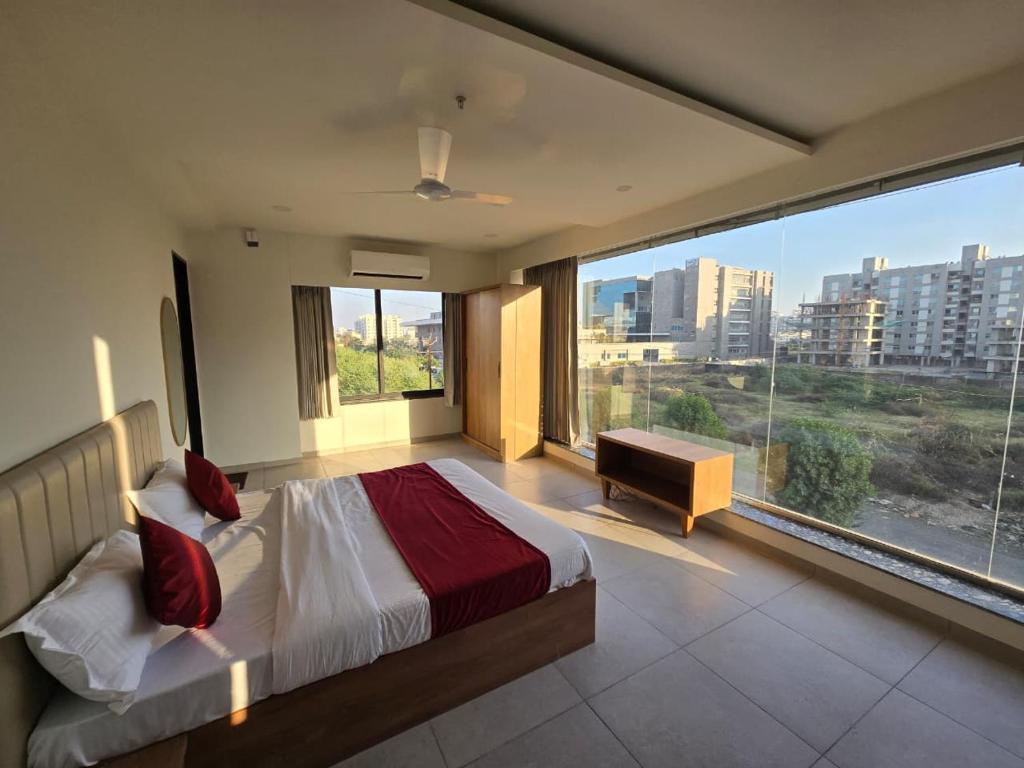 a bedroom with a large bed and a large window at Gajraj Hotel in Vadodara