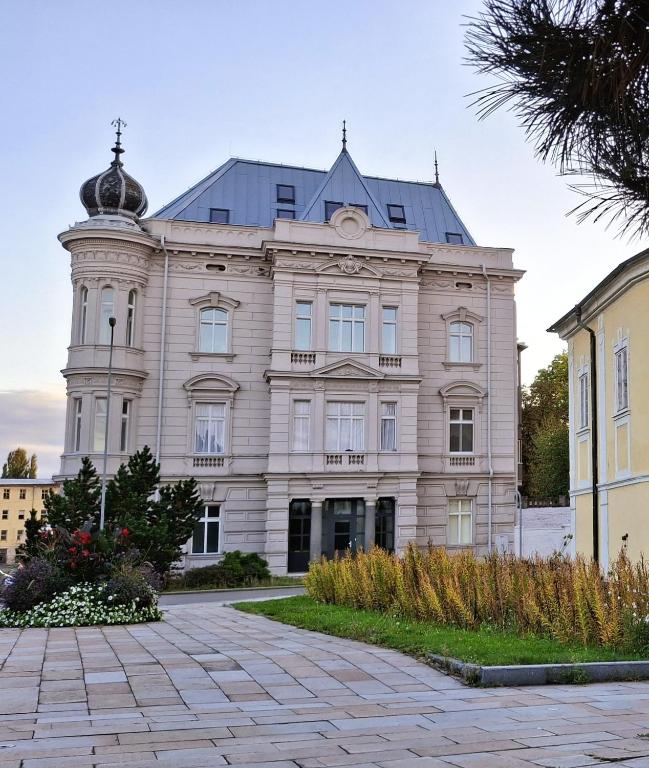 a large white building with a tower on top at Palác Apartment in Strakonice