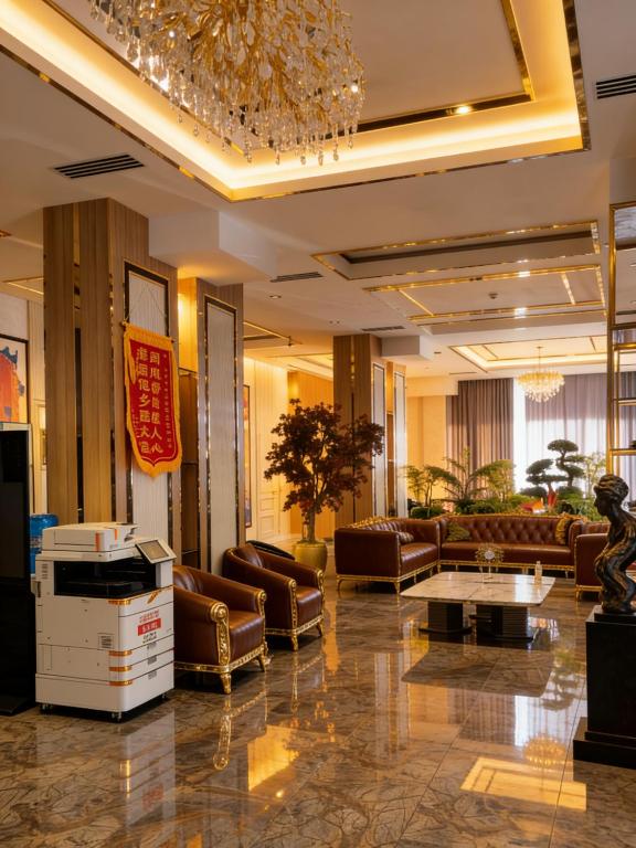 a lobby with leather furniture and a chandelier at Chilonzor Hotel in Tashkent
