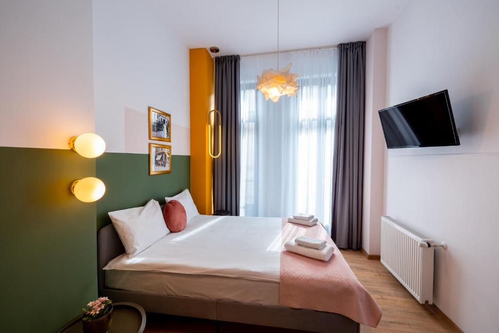 a hotel room with a bed and a tv at Stil Old Town Boutique Hotel in Bucharest