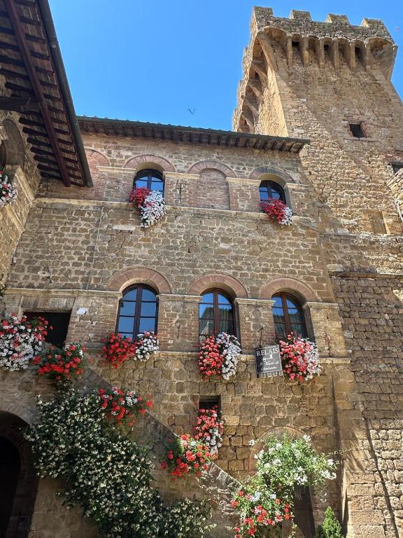 a building with flower boxes on the side of it at Il Mastio di Spedaletto in Pienza