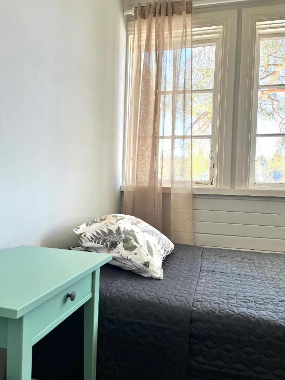 a bed in a room with a desk and a window at Vuohensaari, Rantatalo 2 in Salo