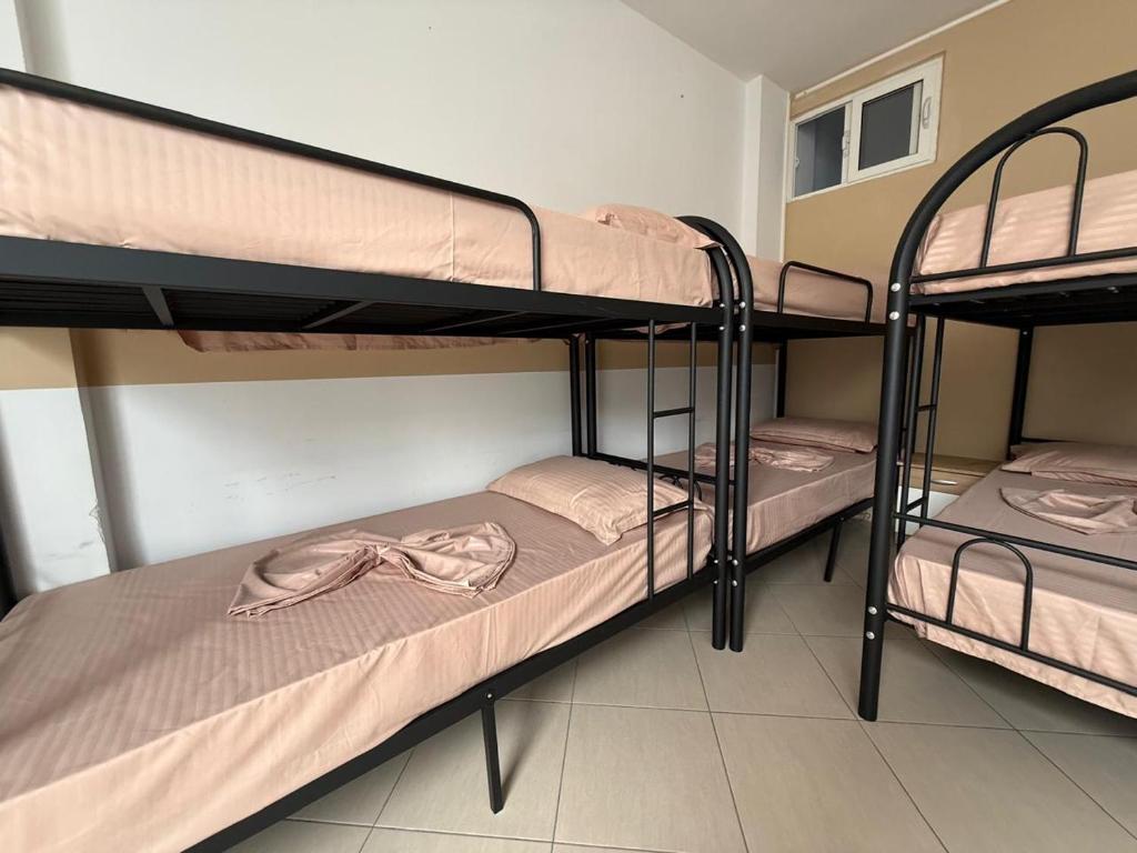two bunk beds in a dorm room with a robe on them at Exeas Hostel in Vlorë