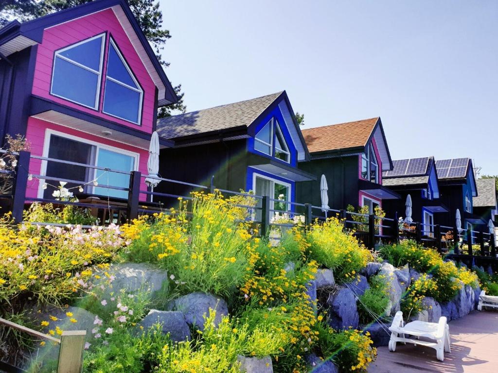 a row of houses with a garden in front at goheung suwan pension in Goheung