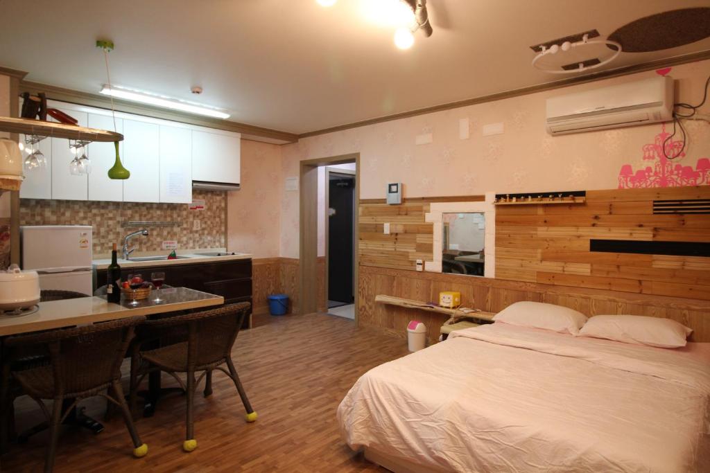 a bedroom with a bed and a kitchen with a counter at Gyeongju Eowoolim Pension in Gyeongju