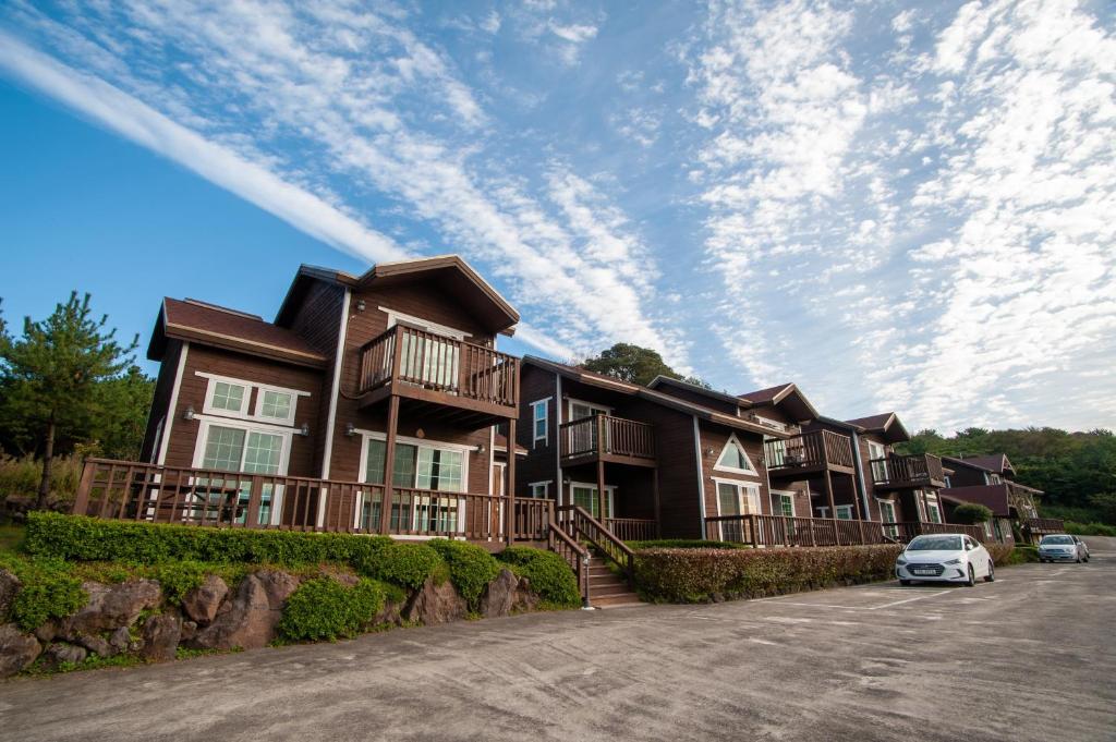 a large house with cars parked in the driveway at Sumang Pension in Seogwipo